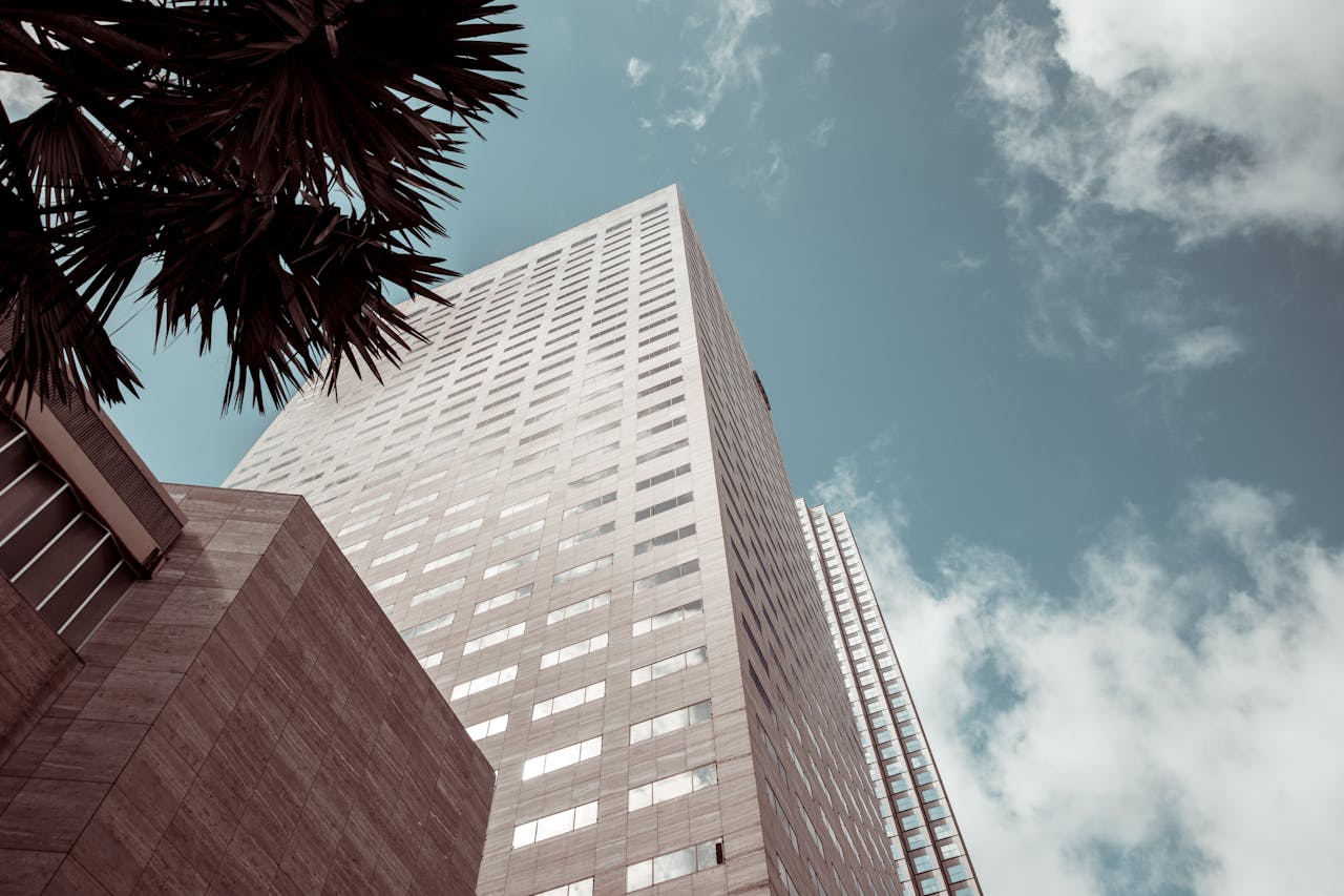 our-services-2 Tall modern building with glass windows against a blue sky in Miami.